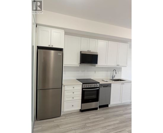 A kitchen with white cabinets and a stainless steel refrigerator.