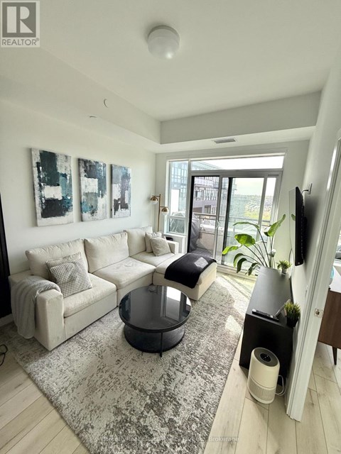A living room with a grey couch and a black coffee table.