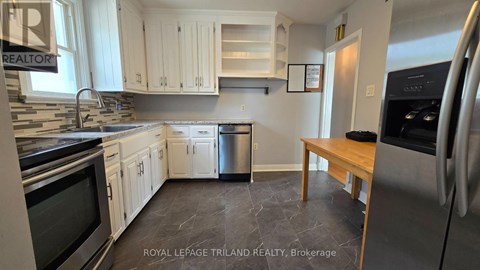A kitchen with white cabinets and a wooden table.