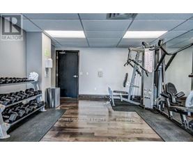A gym with a variety of equipment including weights and cardio machines.