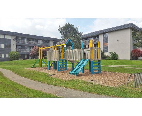 A playground with a blue slide and yellow climbing frame.