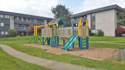 A playground with a blue slide and yellow climbing frame.