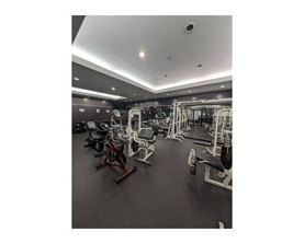 A gym with various exercise machines and weights.