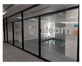 A glass door with a pool in the background and the word steam on the wall.