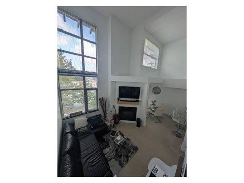 A living room with a black couch and a television.