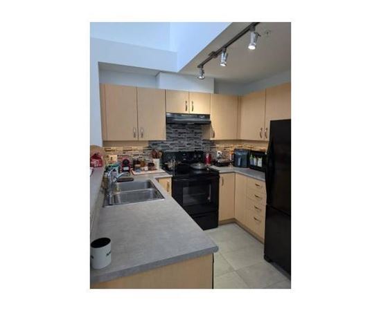 A kitchen with a black stove top oven and a black refrigerator.