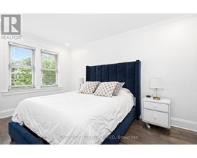 A bedroom with a white bed and a blue headboard.