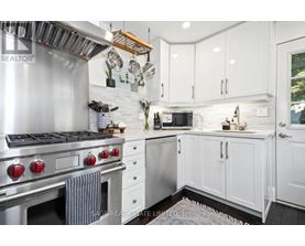 A modern kitchen with white cabinets and a stainless steel stove.