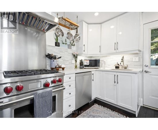 A modern kitchen with white cabinets and a stainless steel stove.