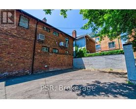 A red brick building with a white fence in front.