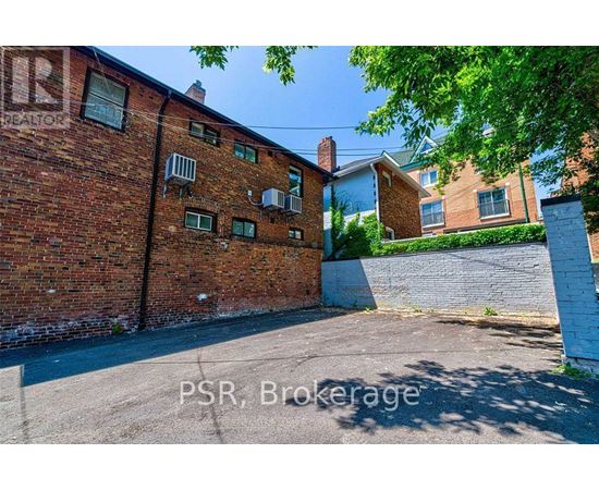 A red brick building with a white fence in front.