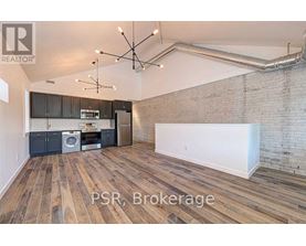 A room with wooden floors and a brick wall is for sale.