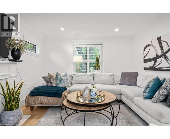 A living room with a white couch, a coffee table, and a window with blinds.