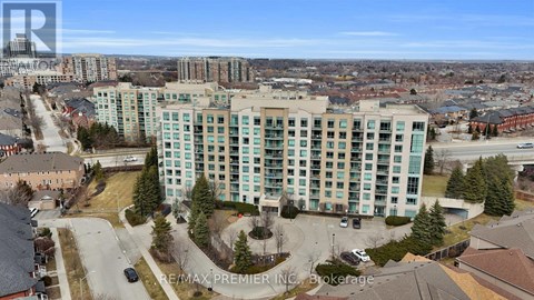 A large multi-story building with a parking lot in front.