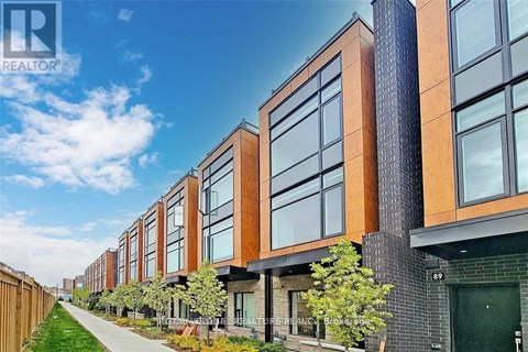 A row of modern townhouses with a clear blue sky above.
