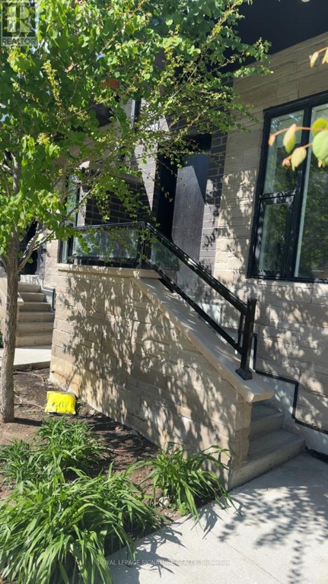 A tree is in front of a building with a window.