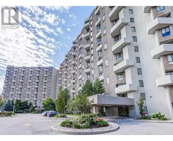 A large apartment complex with a parking lot in front.