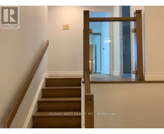 A staircase with a wooden handrail and steps leading to a bright room.