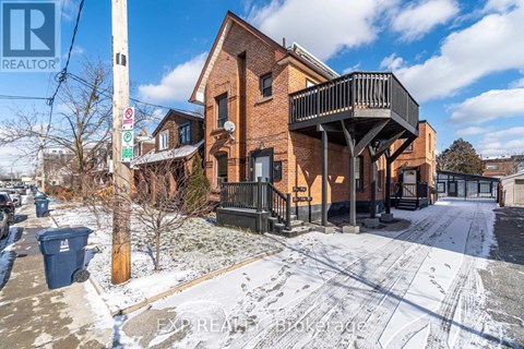 A brick house with a balcony and a sign that says REALTOR.