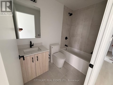 A bathroom with a toilet, sink, and bathtub.