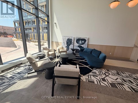 A living room with a large window and a view of a parking lot.