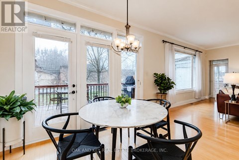 A well-lit, spacious living room with a brown sofa and a glass coffee table.