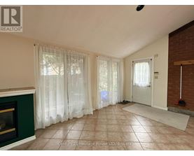 A living room with a fireplace and a door leading to a hallway.