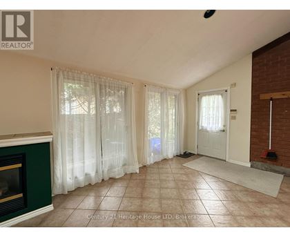 A living room with a fireplace and a door leading to a hallway.