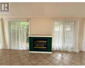 A fireplace in a room with a green mantle and white curtains.