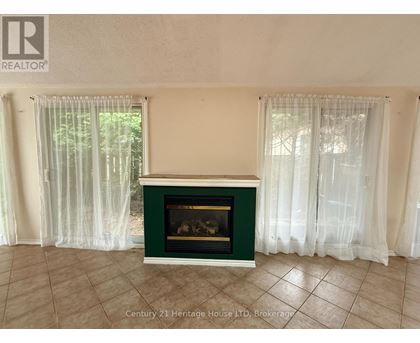 A fireplace in a room with a green mantle and white curtains.