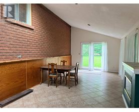 A dining room with a brick wall and a table set for four.