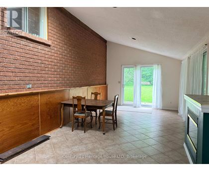 A dining room with a brick wall and a table set for four.