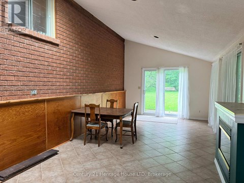 A dining room with a brick wall and a table set for four.