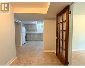 A room with a door leading to a kitchen area.