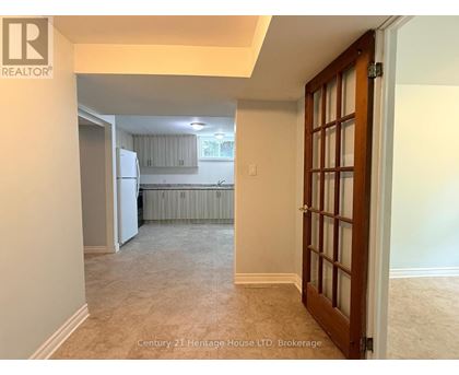 A room with a door leading to a kitchen area.