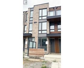 A modern apartment building with a wooden front door and glass windows.