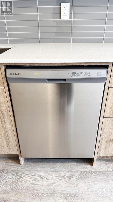 A stainless steel dishwasher is placed in a kitchen.
