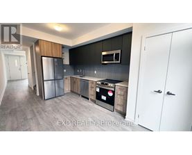 A modern kitchen with a refrigerator, oven, and cabinets.