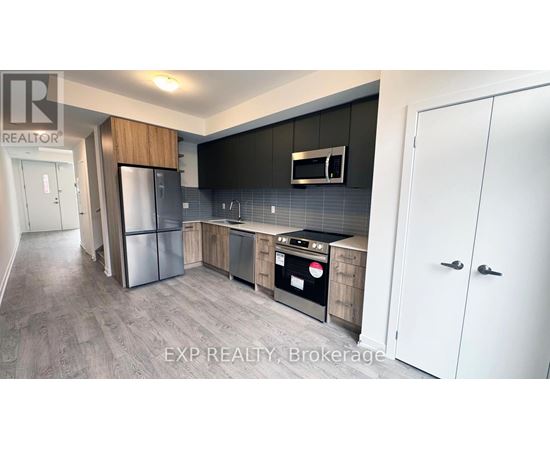 A modern kitchen with a refrigerator, oven, and cabinets.