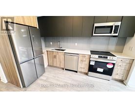 A kitchen with a refrigerator, oven, and microwave.
