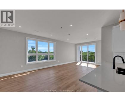 A spacious room with wooden floors and white walls.