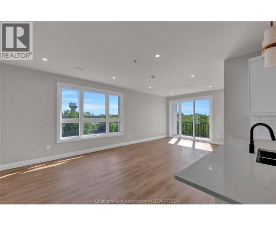 A spacious room with wooden floors and white walls.