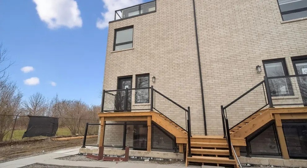 A modern two-story building with a balcony and stairs leading to the upper level.