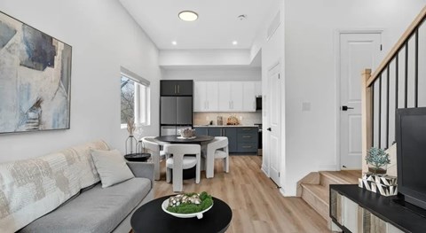 A modern living room with a grey sofa and a black coffee table.