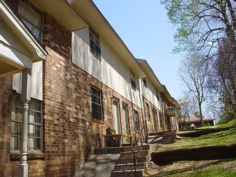 A brick building with a white trim and a porch.