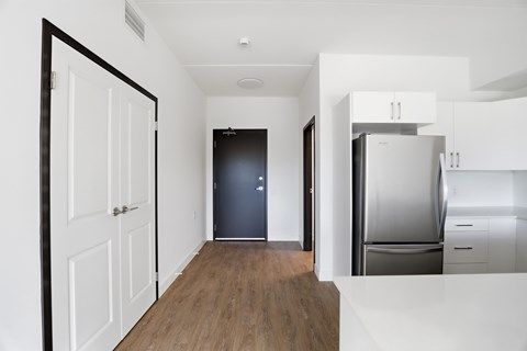 A kitchen with white cabinets and a black refrigerator.