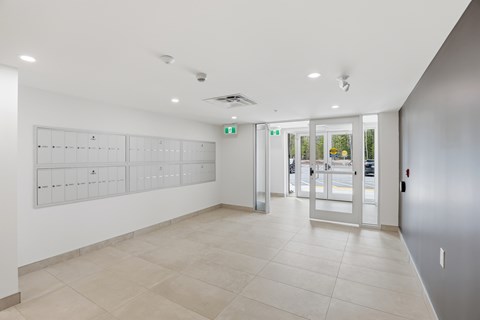 A white hallway with a green exit sign.