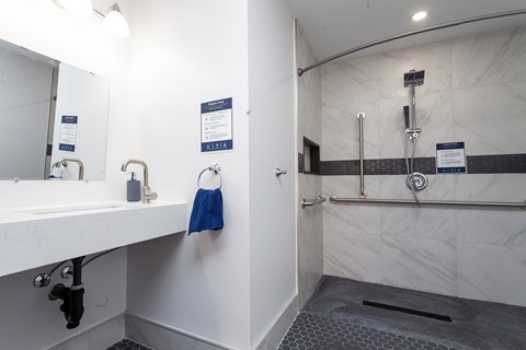 A bathroom with a white sink and a blue towel hanging on the wall.