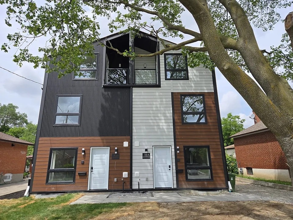 A modern two-story house with a mix of dark and light wooden siding.