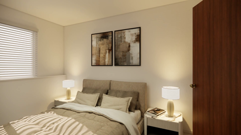 A bedroom with a bed, two lamps, and a painting on the wall.